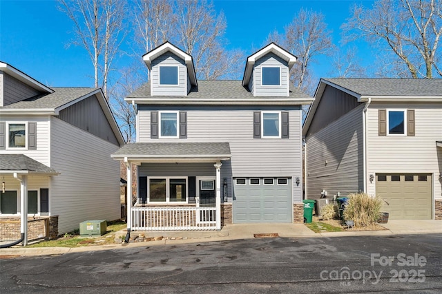 view of front of property with a garage, covered porch, concrete driveway, and roof with shingles