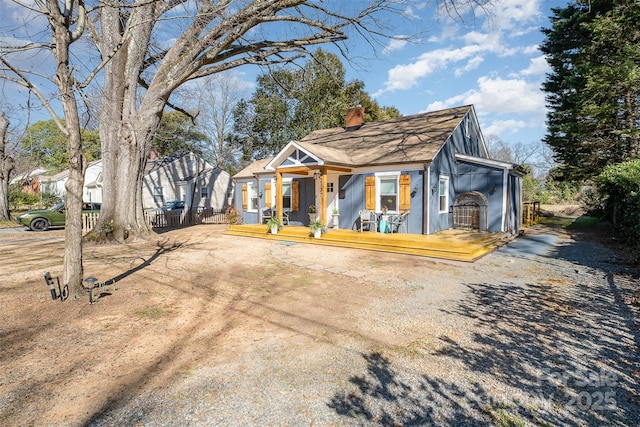 view of front of home featuring a chimney and a porch