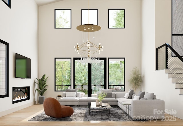 508 Hearthstone Way, Horse Shoe, NC 28742 - living area featuring a glass covered fireplace, a high ceiling, wood finished floors, and a chandelier