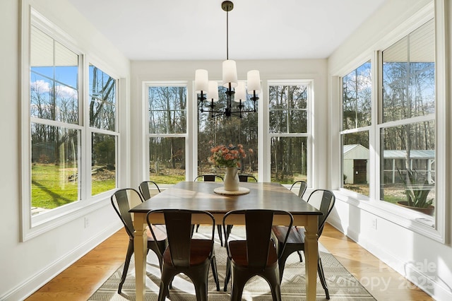 sunroom / solarium featuring a notable chandelier