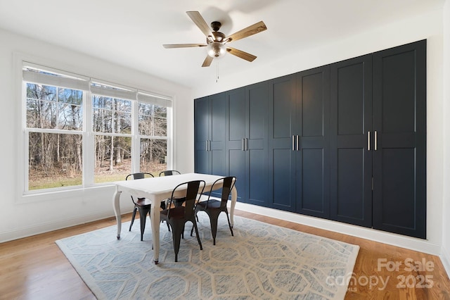 dining area featuring light wood-style floors, ceiling fan, and baseboards