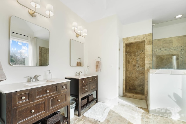 bathroom with two vanities, a sink, and a walk in shower