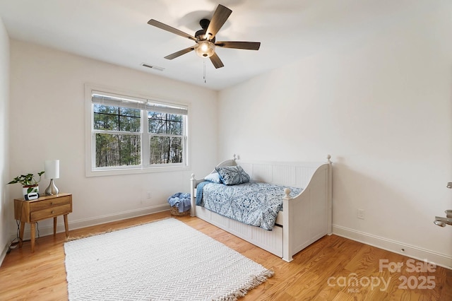 bedroom featuring light wood-style flooring, visible vents, and baseboards