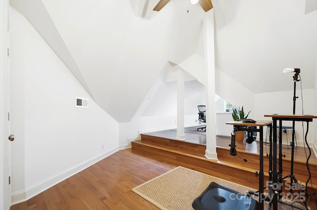 additional living space with lofted ceiling, visible vents, baseboards, wood finished floors, and ornate columns