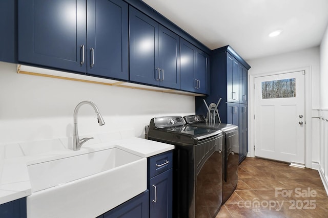 laundry area featuring cabinet space, a sink, and separate washer and dryer