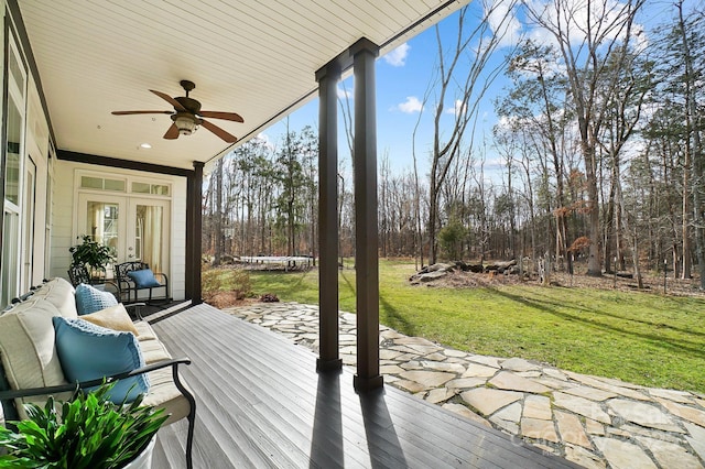 wooden terrace featuring ceiling fan, a yard, french doors, a trampoline, and a patio area