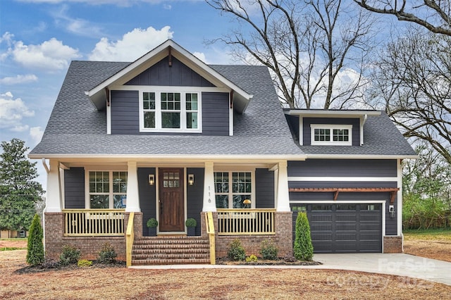 craftsman inspired home featuring roof with shingles, covered porch, concrete driveway, an attached garage, and brick siding