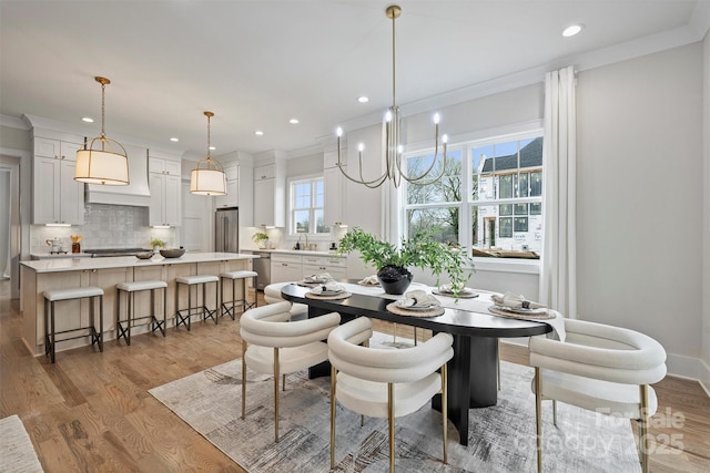 dining area with recessed lighting, light wood-type flooring, baseboards, and crown molding