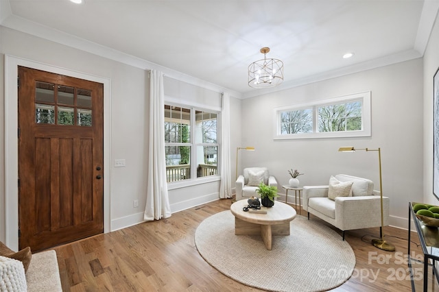 living area featuring crown molding, baseboards, recessed lighting, wood finished floors, and a notable chandelier