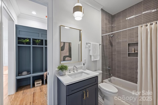 bathroom featuring vanity, toilet, wood finished floors, and shower / bath combo with shower curtain