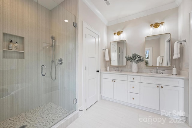 full bathroom featuring double vanity, ornamental molding, a stall shower, and a sink