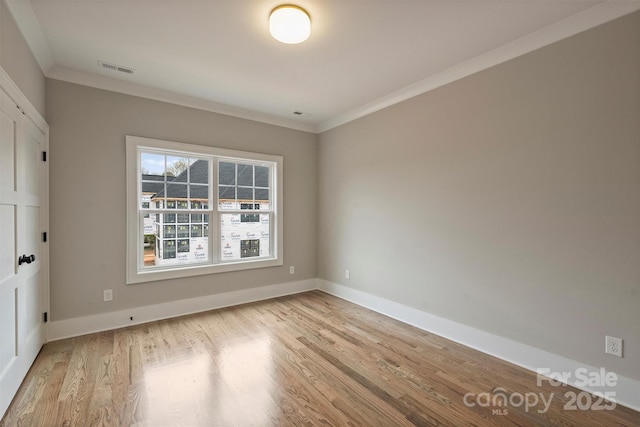 unfurnished room featuring light wood-style flooring, baseboards, and ornamental molding