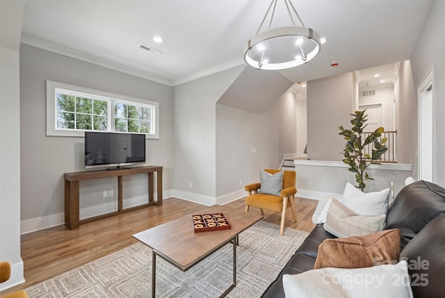 living room featuring ornamental molding, wood finished floors, visible vents, and baseboards