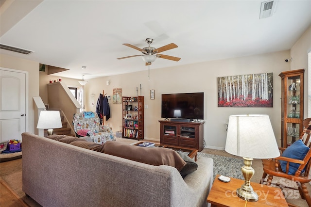 living room featuring ceiling fan, visible vents, and baseboards