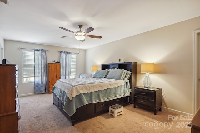 bedroom with a ceiling fan, light carpet, visible vents, and baseboards