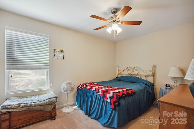 bedroom with ceiling fan, baseboards, and light colored carpet