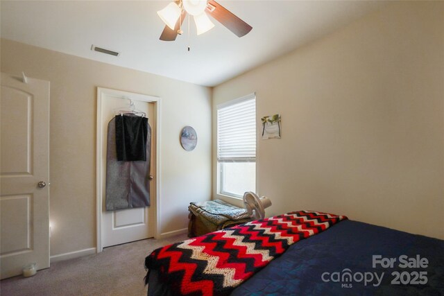 carpeted bedroom featuring ceiling fan, visible vents, and baseboards