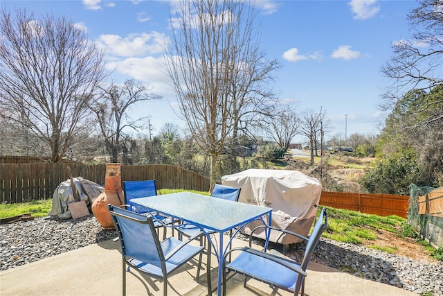 view of patio with outdoor dining space, a fenced backyard, and area for grilling