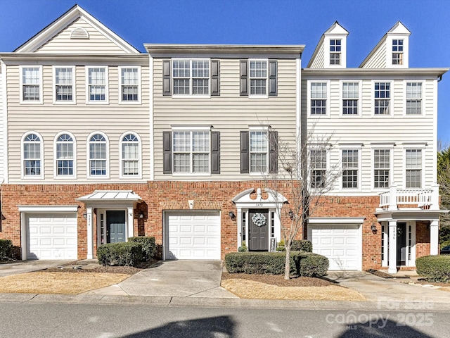 view of property with concrete driveway, brick siding, and an attached garage