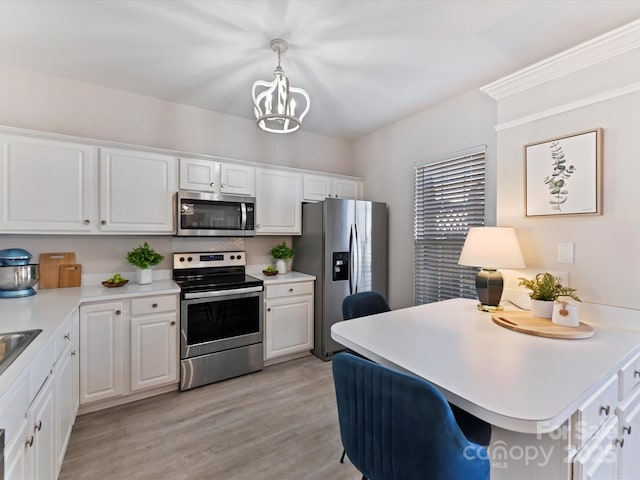 kitchen featuring light countertops, appliances with stainless steel finishes, light wood-style floors, and white cabinets