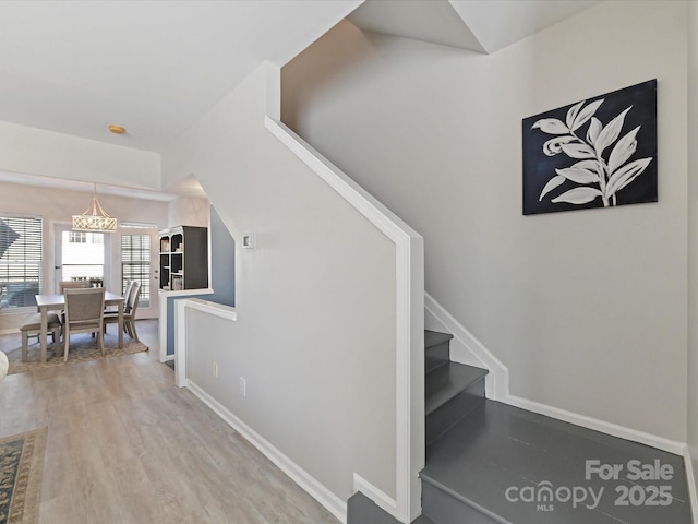 stairway with baseboards and wood finished floors