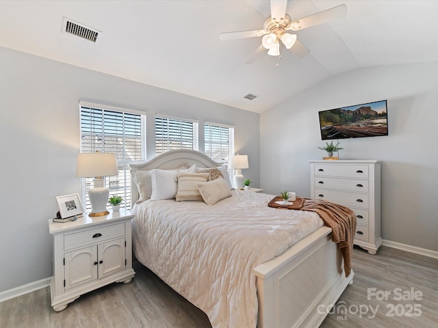 bedroom with lofted ceiling, visible vents, and light wood-style flooring