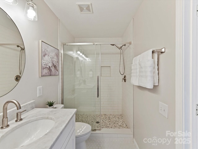 full bath with visible vents, a shower stall, toilet, and vanity