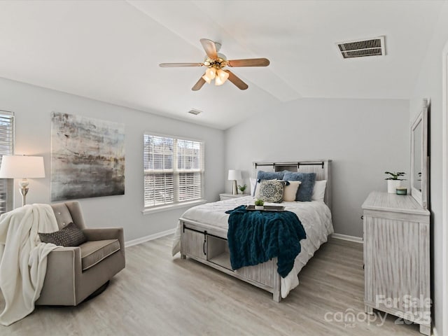 bedroom featuring lofted ceiling, light wood-type flooring, visible vents, and baseboards