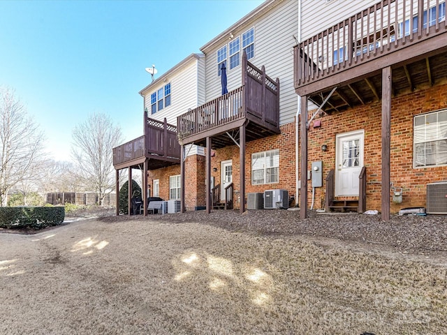 back of property with entry steps, central AC, and brick siding