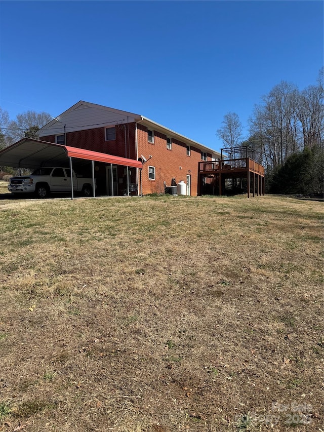 view of yard with a detached carport, a wooden deck, and central AC unit