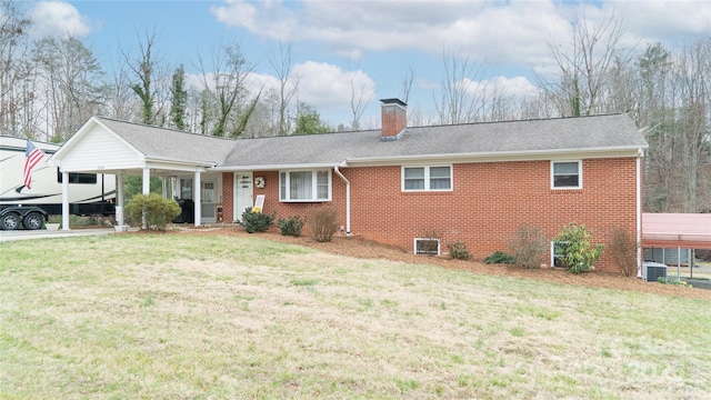 ranch-style home featuring brick siding, roof with shingles, a front yard, a chimney, and a carport