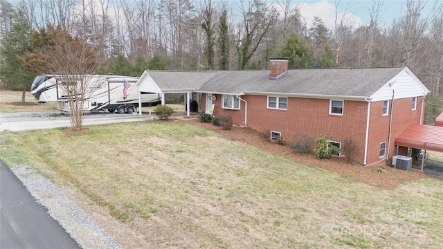 single story home with a front yard, cooling unit, a chimney, a carport, and brick siding