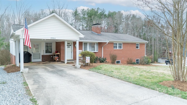 ranch-style house featuring an attached carport, concrete driveway, brick siding, and a chimney