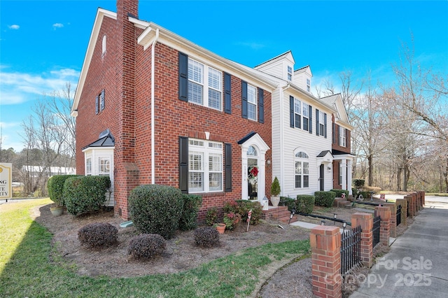 view of front of house with a chimney and brick siding