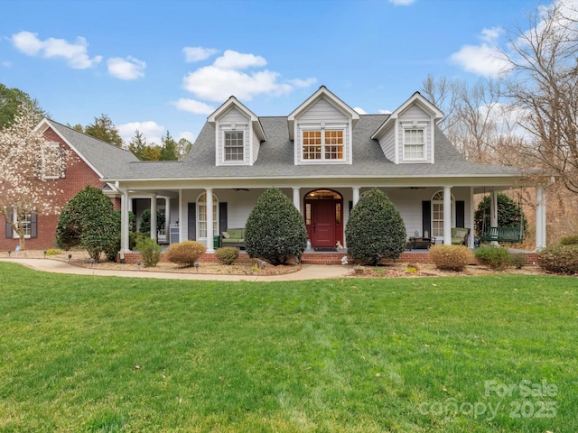 cape cod home with a porch, a shingled roof, and a front lawn