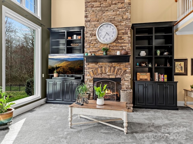 living area with carpet floors, a fireplace, and baseboards