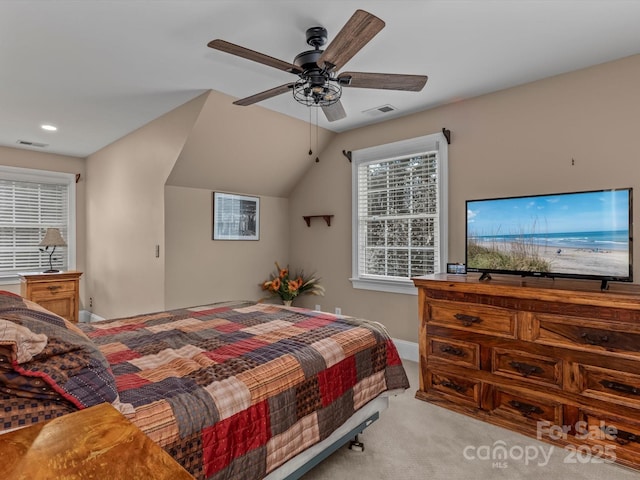 bedroom featuring a ceiling fan, visible vents, vaulted ceiling, and carpet flooring