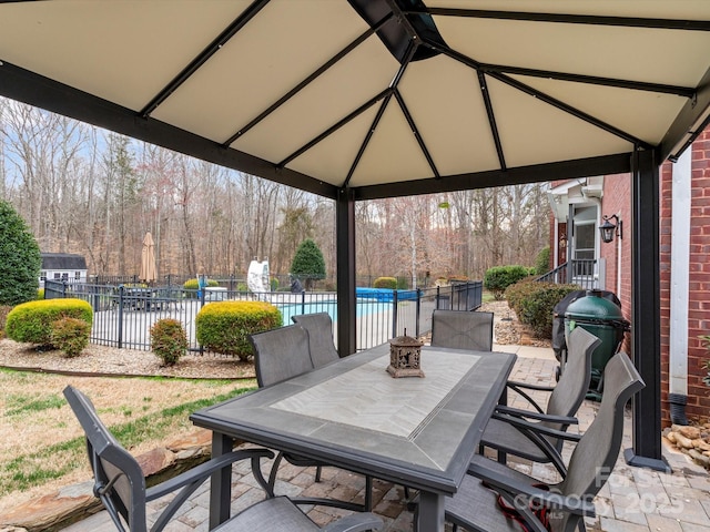 view of patio featuring a fenced in pool, outdoor dining area, fence, and a gazebo