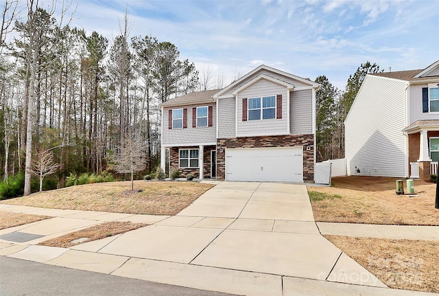 view of front facade featuring a garage, concrete driveway, and stone siding