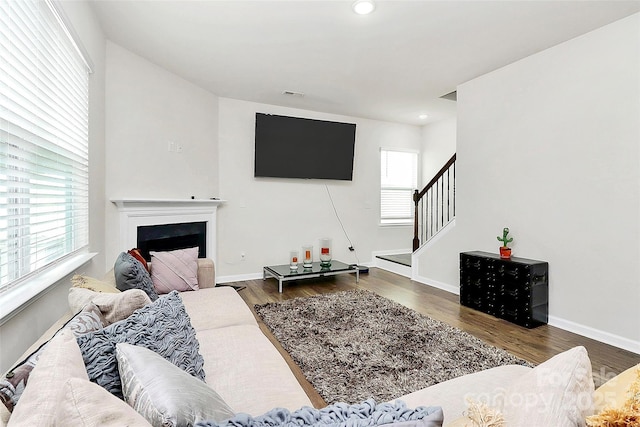 living room with wood finished floors, baseboards, and stairs