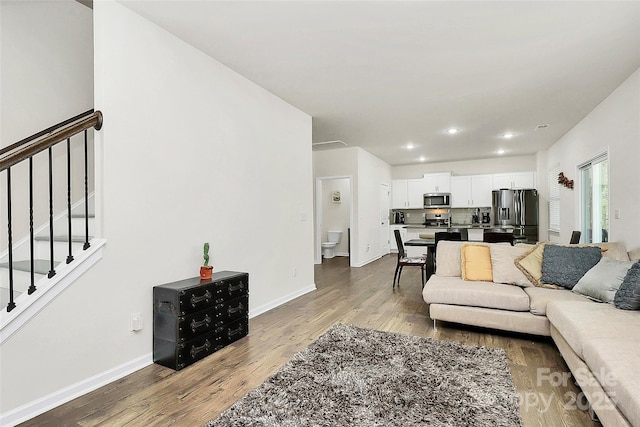 living area featuring stairway, recessed lighting, wood finished floors, and baseboards