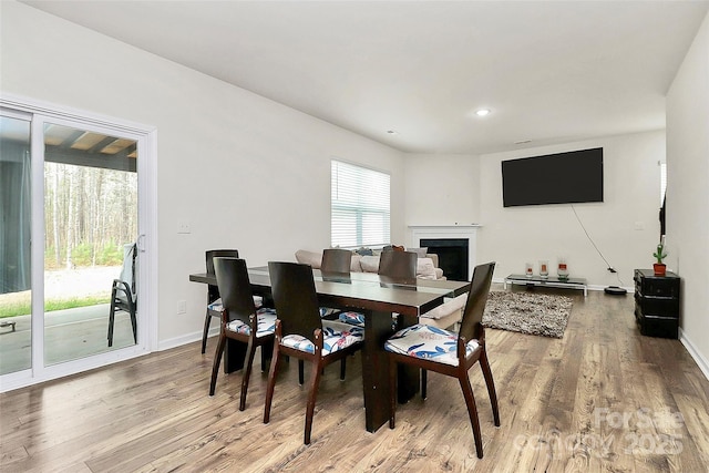 dining area with recessed lighting, a fireplace, baseboards, and wood finished floors