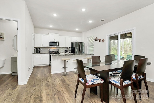 dining area featuring baseboards, visible vents, dark wood-type flooring, and recessed lighting