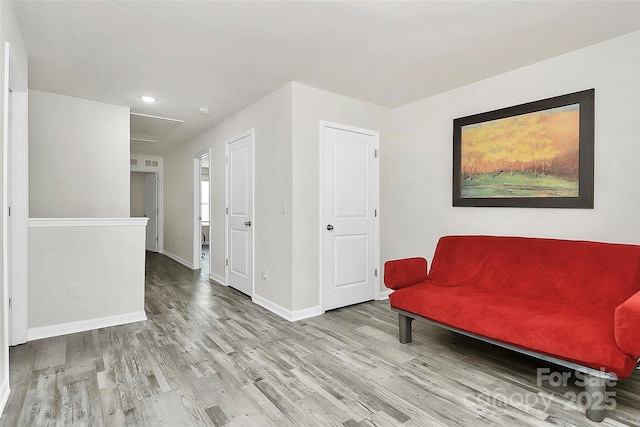 living area with baseboards and wood finished floors