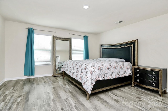 bedroom featuring wood finished floors, visible vents, and baseboards