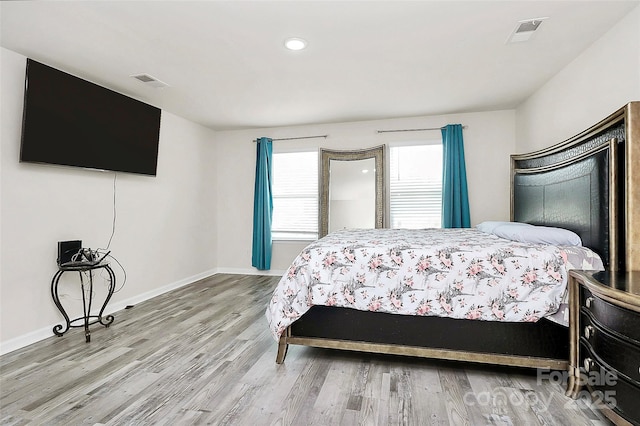 bedroom with recessed lighting, wood finished floors, visible vents, and baseboards