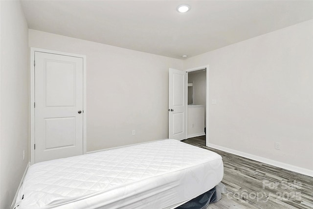 bedroom with baseboards and wood finished floors