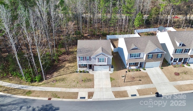 drone / aerial view featuring a wooded view