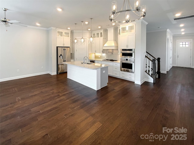 kitchen featuring custom exhaust hood, crown molding, appliances with stainless steel finishes, and a sink