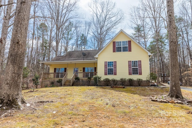 view of front facade featuring covered porch and a shingled roof